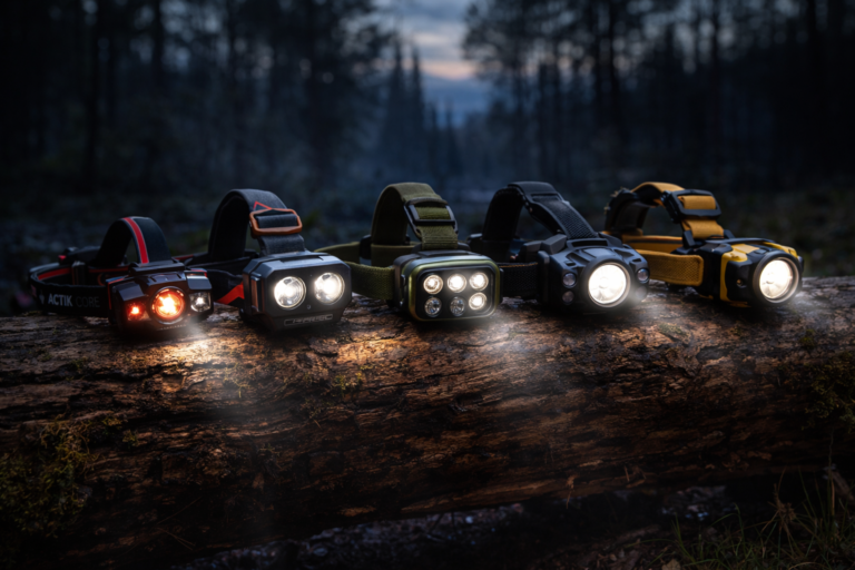 Kilka latarek czołowych świecących w lesie po zmroku